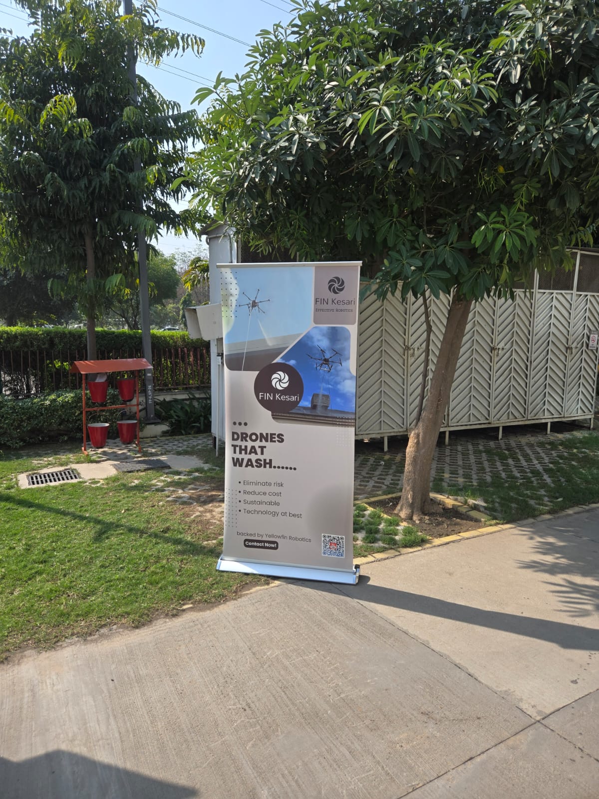 Fin Kesari banner on a sunny launch day surrounded by greenery