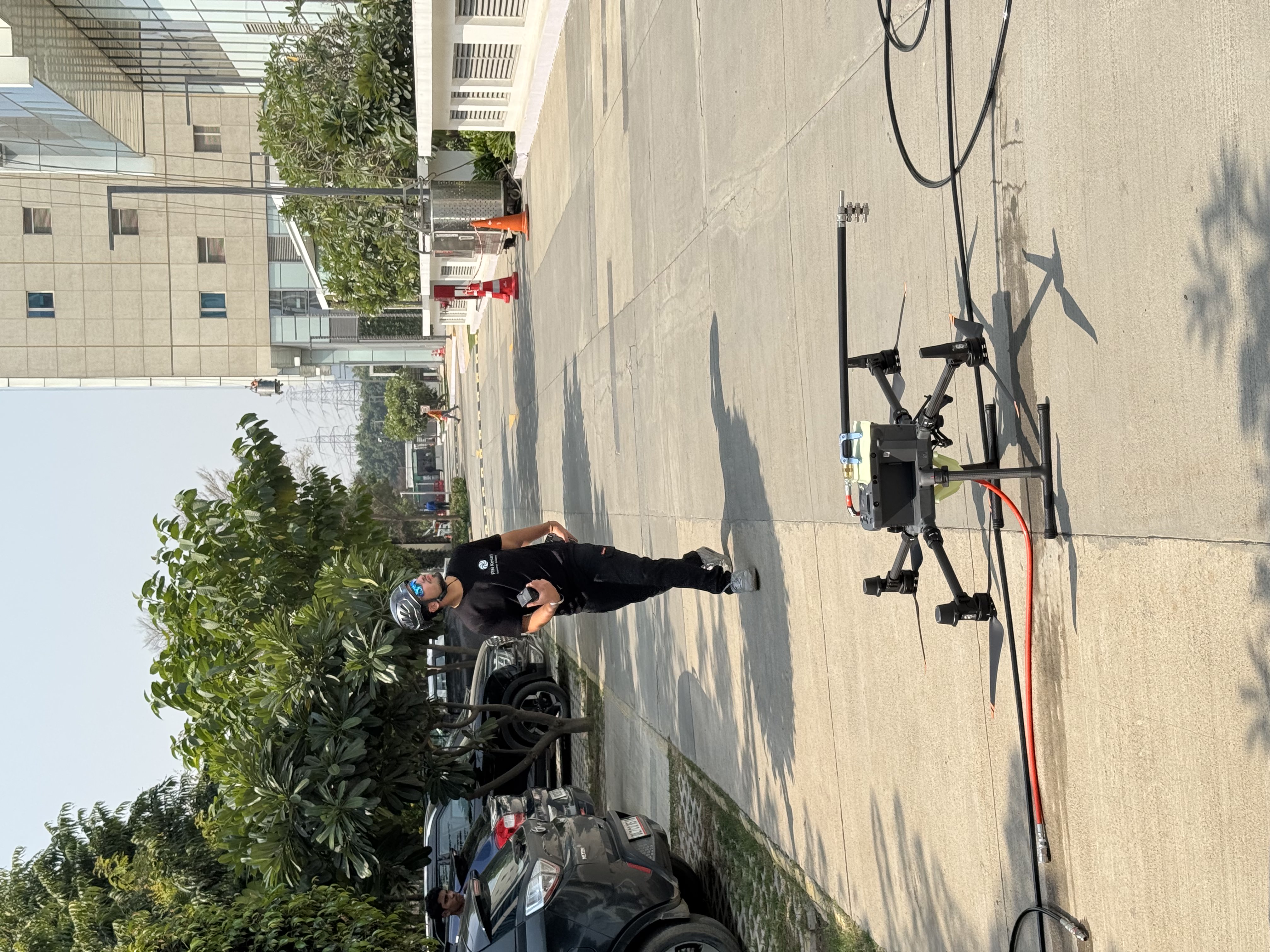Fin Kesari pilot walking beside the Aero-Wash® drone during pre-flight checks