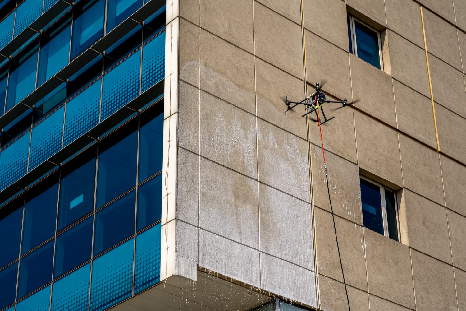 House soft wash with drone hovering above roofline